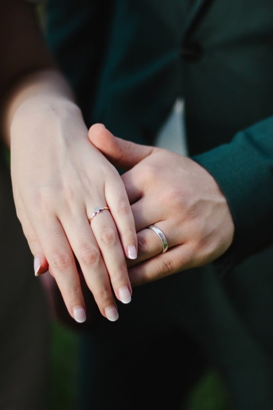 Our hands together, wearing our rings